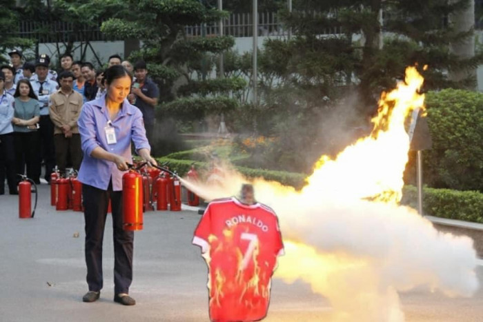 Người phụ nữ cầm bình cứu hỏa xịt chữa cháy áo Ronaldo bị đốt
